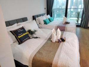 吉隆坡OPUS RESIDENCE KL I HomeBrickz的一间设有三张鲜花的床的房间