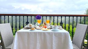 纳隆河畔穆罗斯普拉亚德阿吉拉尔乡村酒店的阳台上配有带食品和饮料的白色桌子