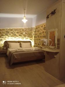 VolissosΠεριβόλι του Οδυσσέα的一间卧室配有一张石墙床