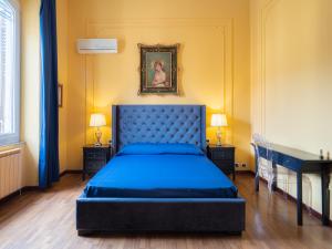 斯培西亚歌剧院旅馆的卧室配有蓝色的床和墙上的绘画作品