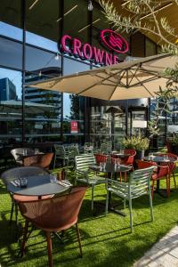 尼斯Crowne Plaza - Nice - Grand Arenas, an IHG Hotel的一间带桌椅和遮阳伞的餐厅