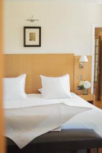 勒韦尔努瓦德乐伟诺酒店的卧室内的一张带白色床单和枕头的床