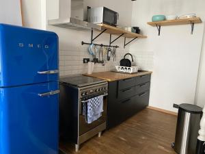 列日Vivegnis, little cosy house的厨房配有蓝色冰箱和炉灶。