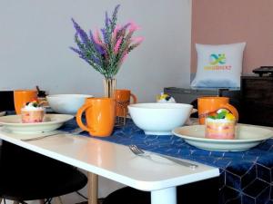 莎阿南Avenue Crest 4PAX STUDIO Shah Alam I HomeBrickz的桌上放有盘子,碗和花