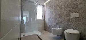 莱切省卡斯特罗Bona Vitae - Attico Vista Mare Castro的一间带卫生间和玻璃淋浴间的浴室