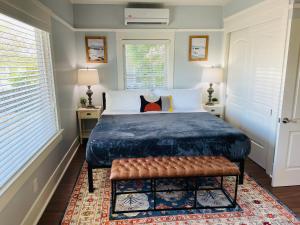 圣地亚哥Fern House South Park Craftsman的一间卧室配有一张带长凳的床和两个窗户。