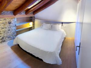 卡尼略Cal Potablanc的石墙房间内的一张白色床