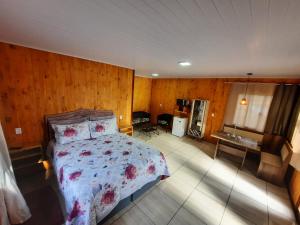 坎巴拉Cânions de Cambará的卧室配有一张床铺,位于带木墙的房间内