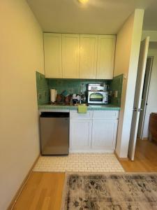 阿默甘西特阿玛甘赛特海洋沙丘公寓的小厨房配有白色橱柜和微波炉