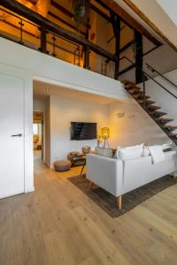 马斯特里赫特Madrid Suites的客厅设有白色沙发和楼梯。