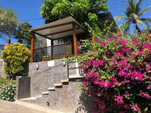 Playa San BlasEl Salvador Surf Houses的花朵在房子前面的楼梯