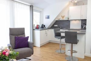 翁德洛Heideträume Appartements的厨房配有沙发、椅子和桌子