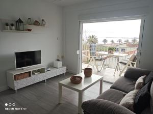 德尼亚Apartamento acogedor en primera linea de playa的带沙发和电视的客厅