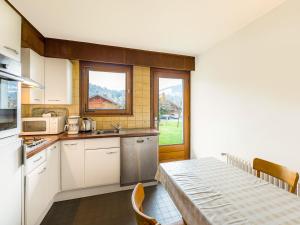 梅杰夫Appartement Megève, 2 pièces, 4 personnes - FR-1-453-91的厨房配有白色橱柜、桌子和窗户。