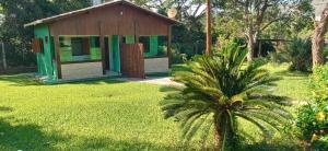 西波山Chalés Jardim da Serra的院子内有棕榈树的小房子
