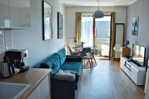 索波特Sopotinn Apartment的客厅配有蓝色的沙发和桌子