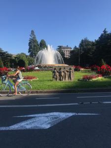 圣塞瓦斯蒂安Apartamento PioXII Center的一位在喷泉前骑着自行车的女人
