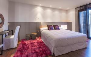 SarratellaHotel Boutique Abadia del Maestrat的卧室配有一张白色大床和红色地毯。