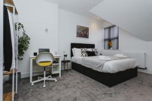 诺丁汉1 Bed Stylish City Flat 2nd Floor close to City Centre with free parking, king size bed & Wi-Fi的一间卧室配有一张床、一张桌子和一把椅子