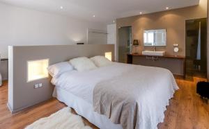 SarratellaHotel Boutique Abadia del Maestrat的一间带白色大床的卧室和一间浴室