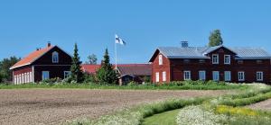 Petäjävesi莱米提拉乡村住宿酒店的一座大型红谷仓,一座房子和一座田野