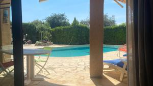 La Roquette-sur-Siagne2 Pièces Rdc Villa Piscine的庭院设有桌椅,享有游泳池的景色。