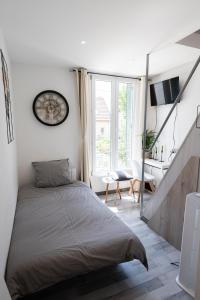 讷伊-普莱桑斯Warm Studio en duplex proche Paris et Disney的一间卧室配有一张大床和一张书桌