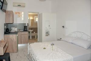 扎金索斯镇Petros Giatras - Rooms的一间带白色大床的卧室和一间厨房