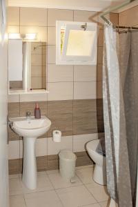 扎金索斯镇Petros Giatras - Rooms的一间带水槽和卫生间的浴室以及窗户。