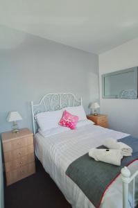 兰迪德诺Montague House Apartments的一间卧室配有一张带粉红色枕头的大床