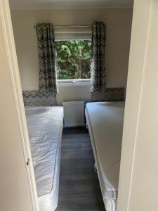 埃尔默洛Mooi verblijf op rustig park的小房间设有两张床和窗户