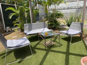 帕皮提TAHITI - Fare Vairai Pool的两把椅子和一张桌子放在草地上