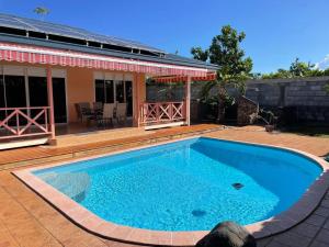 帕皮提TAHITI - Fare Vairai Pool的一座大蓝色游泳池,位于房子前