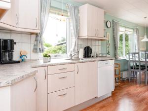 埃贝尔托夫特Holiday home Ebeltoft CXCIV的一间厨房,配有白色橱柜和一间餐厅