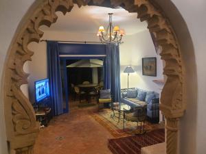 布兹尼盖Villa à Bouznika Bay-plage et golf的客厅的拱门,客厅配有蓝色的沙发