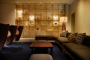 金泽HOTEL AMANEK Kanazawa的带沙发、桌子和书架的客厅
