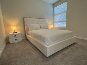 洛杉矶ViewPoint Suites的一间卧室配有一张带两盏灯的大型白色床。