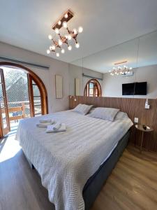 坎波斯杜若尔当Flat da Babi, MODERNO, LUXUOSO, EQUIPADO e 600mb wifi的一间卧室配有一张大床和两条毛巾