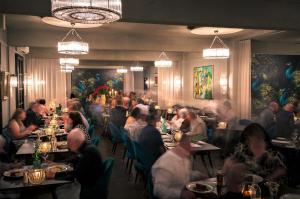 奥兰治The Oriana Orange - Retro Hotel & Resort的一群坐在餐厅桌子上的人