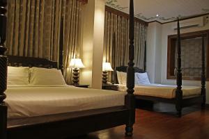 美岸威尼托德维甘酒店的一间卧室配有两张床和两盏灯。