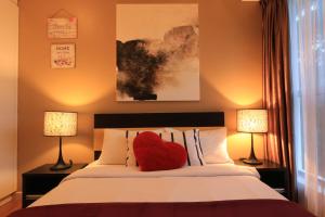 吉隆坡Suasana Bukit Ceylon Residence的床上的红色心枕,带两盏灯