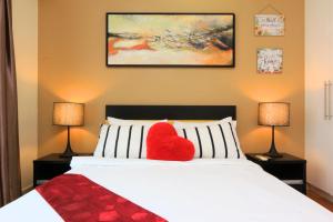吉隆坡Suasana Bukit Ceylon Residence的床上的红色心枕,带两盏灯