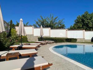 索佐波尔Villa Mia的游泳池旁设有长椅和遮阳伞的游泳池
