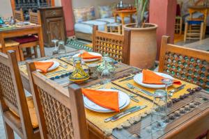 马拉喀什大戟摩洛哥传统庭院住宅的一张桌子,上面有橙色餐巾和盘子