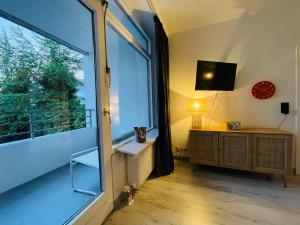 达默Apartment Sünnanbeter mit Pool für 2-4 Personen的客房设有窗户、桌子和电视。