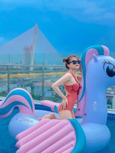 岘港岘港玛丽兰德酒店的穿着泳衣的年轻女孩站在充气式上