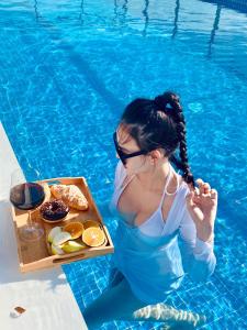岘港岘港玛丽兰德酒店的坐在游泳池里带餐盘的女人