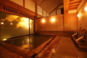 野沢野沢温泉　奈良屋旅館的木墙房间里一个大水池