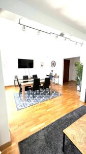 圣格拉蒂安Superbe appartement en centre-ville, 20min de Paris, 5 min d'Enghien的客厅配有桌椅和电视。