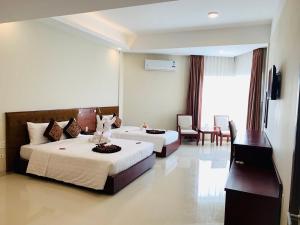 洞海Duy Tân Quảng Bình Hotel & Resort的酒店客房设有两张床和电视。